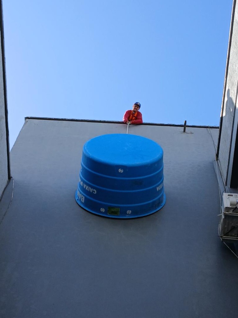 Içamento de caixa d’água com talha e equipamento de proteção em prédio